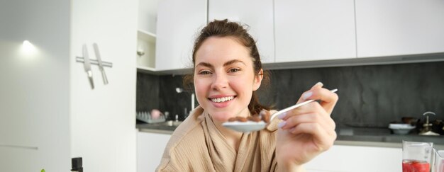 Portrait d'une jeune femme souriante debout à la maison