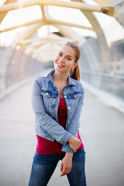 Photo portrait d'une jeune femme souriante debout sur un pont