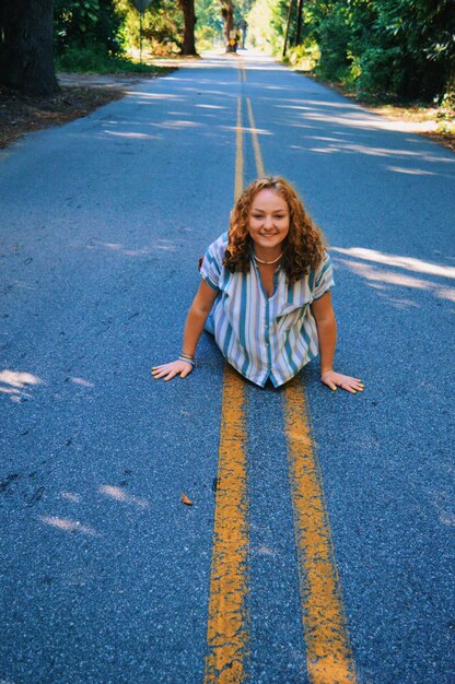 Photo portrait d'une jeune femme souriante debout sur la route