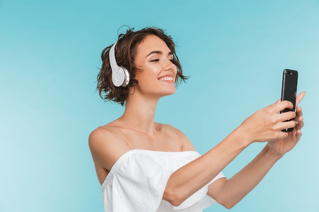 Portrait d'une jeune femme souriante écoutant de la musique