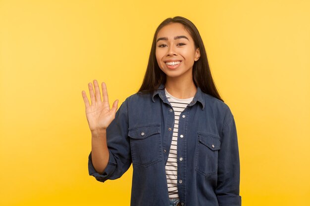 Photo portrait d'une jeune femme souriante sur un fond jaune