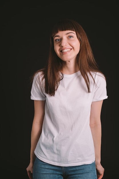 Portrait d'une jeune femme souriante sur un fond noir