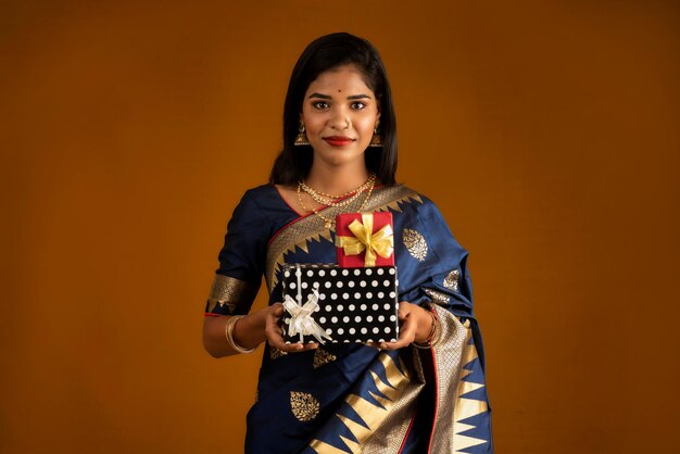 Portrait de jeune femme souriante heureuse ou fille tenant une boîte-cadeau