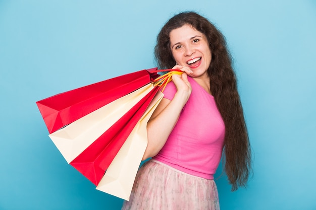 Portrait de jeune femme souriante heureuse avec des sacs à provisions. Concept d'achat, de vente et de personnes