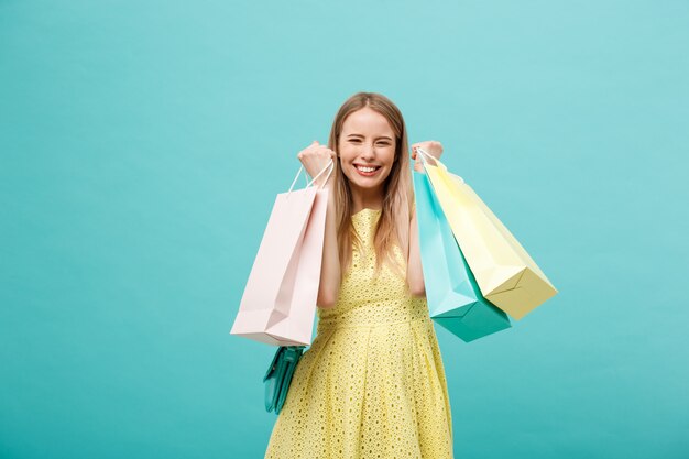 Portrait de jeune femme souriante heureuse avec des sacs à provisions.