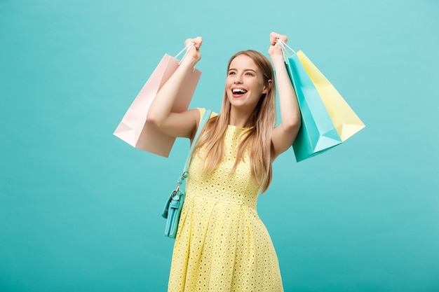 Portrait de jeune femme souriante heureuse avec des sacs à provisions.