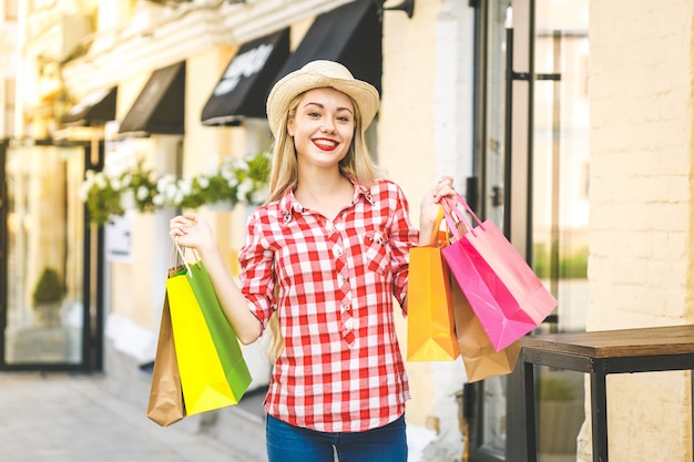 Portrait de jeune femme souriante heureuse avec des sacs à provisions