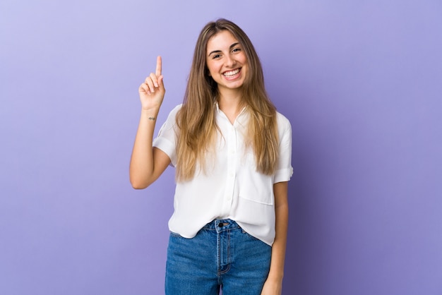 Portrait d'une jeune femme souriante pointant vers le haut