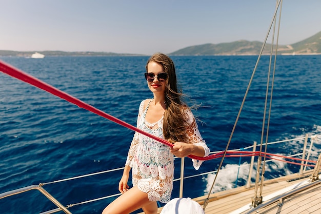 Photo portrait d'une jeune femme souriante portant un bikini debout dans un bateau en mer