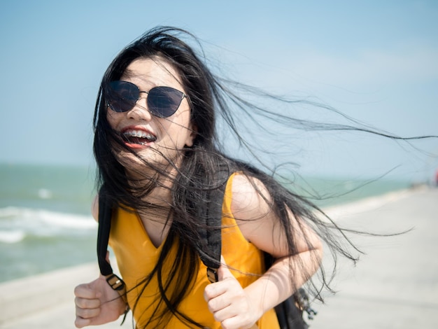 Portrait d'une jeune femme souriante portant des lunettes de soleil