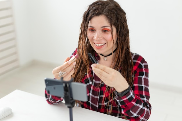 Portrait d'une jeune femme souriante tenant une caméra