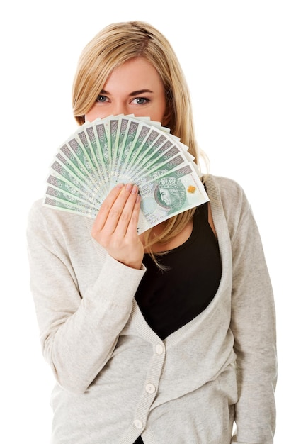 Portrait d'une jeune femme souriante tenant du papier-monnaie sur un fond blanc