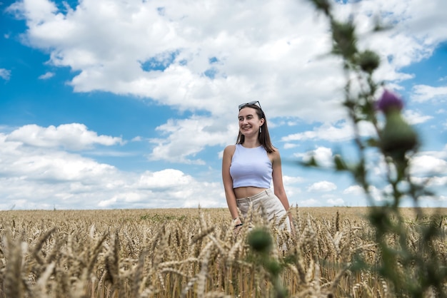 Portrait de jeune femme sportive sur le champ de blé en été. mode de vie