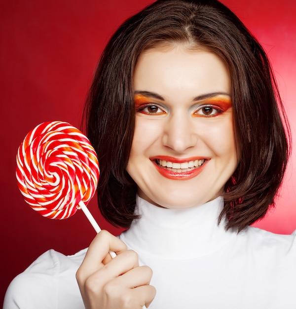 Portrait de jeune femme avec sucette sur rouge