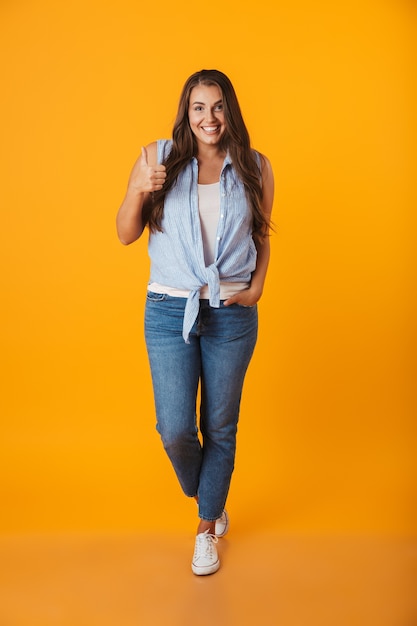 Portrait d'une jeune femme en surpoids souriante, montrant les pouces vers le haut