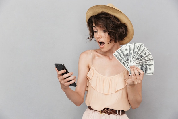 Portrait d'une jeune femme surprise en chapeau d'été