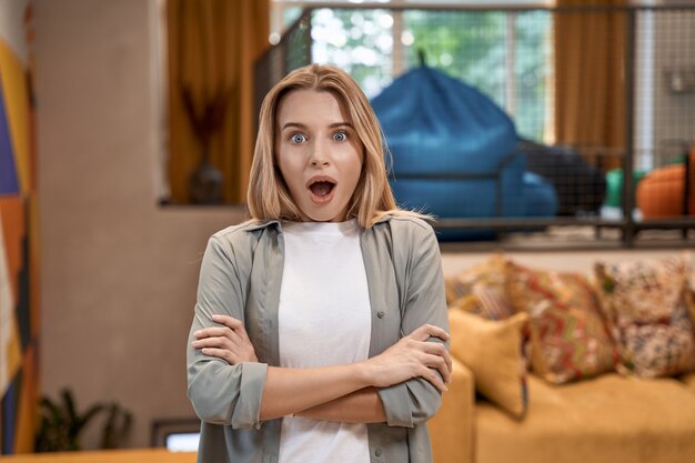 Portrait d'une jeune femme surprise employée de bureau gardant la bouche ouverte et regardant la caméra