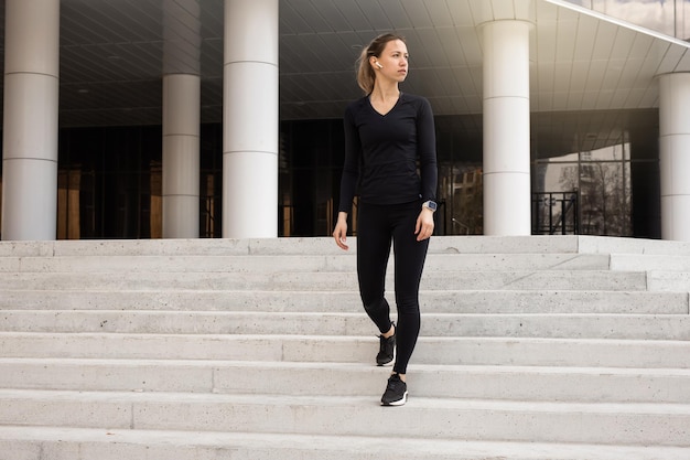 portrait d'une jeune femme en survêtement noir faisant de la gymnastique