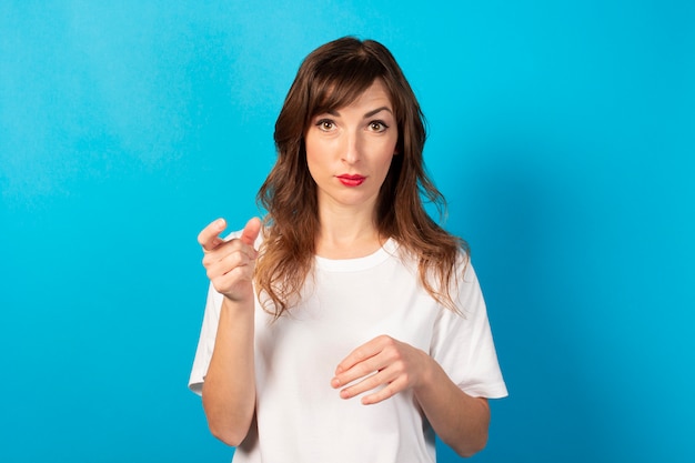 Portrait D'une Jeune Femme Sympathique En T-shirt Décontracté Sur Bleu. Visage émotionnel