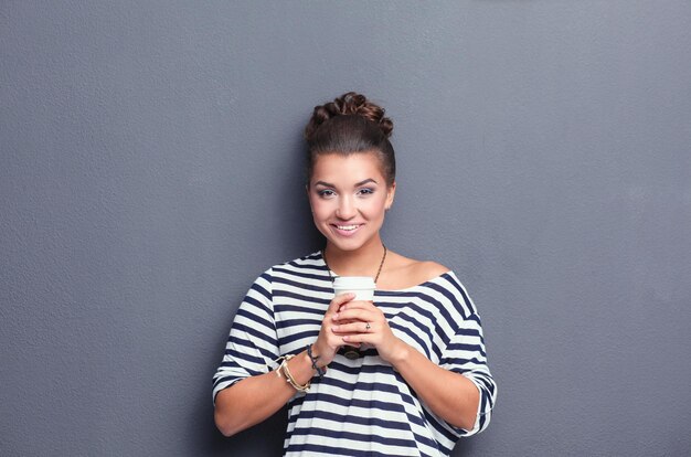 Portrait d'une jeune femme avec une tasse de thé ou de café.