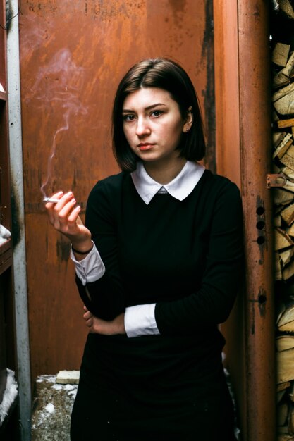 Portrait d'une jeune femme tenant une cigarette