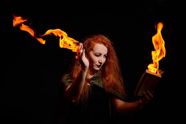 Photo portrait d'une jeune femme tenant le feu sur un fond noir