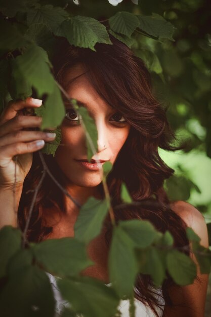 Photo portrait d'une jeune femme tenant des feuilles