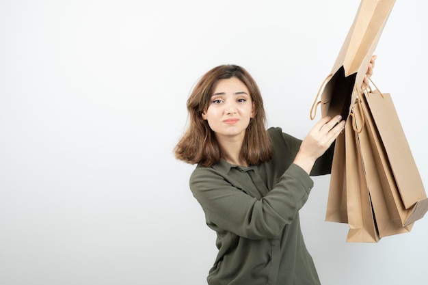 Portrait de jeune femme tenant des sacs en papier et debout. Photo de haute qualité