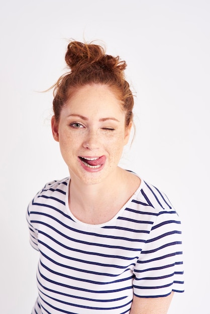 Photo portrait d'une jeune femme tendant la langue sur un fond blanc