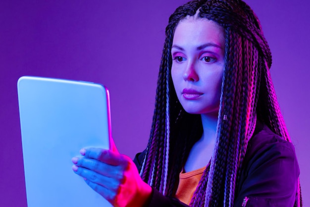 Photo portrait, de, a, jeune femme, tenue, tablette numérique, dans, lumière néon