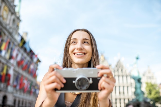 Portrait d'une jeune femme touriste avec appareil photo sur la place du Grand Marché dans la ville d'Anvers en Belgique