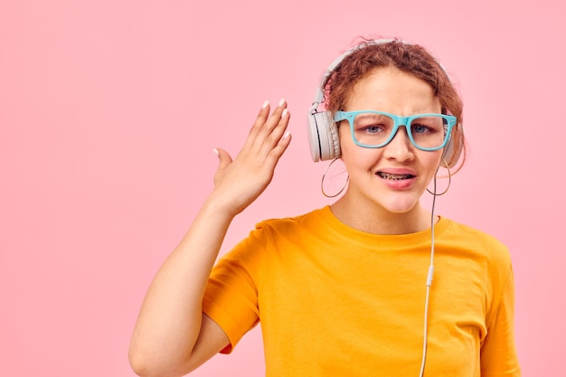 Portrait d'une jeune femme tshirt jaune casque divertissement musique fun arrière-plans isolés inchangés