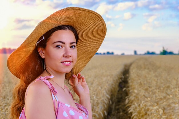 Portrait de jeune femme ukrainienne aux cheveux longs souriante dans un chapeau de paille