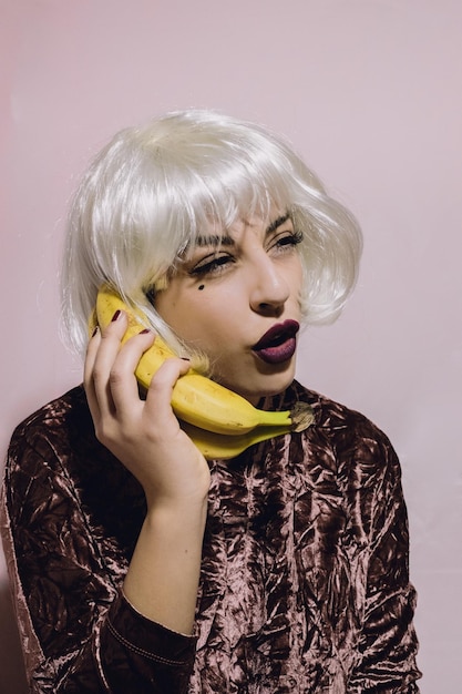 Photo portrait d'une jeune femme utilisant une banane comme téléphone