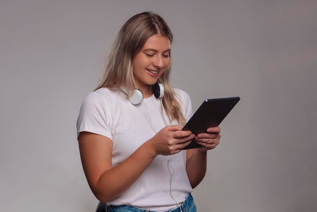 Portrait de jeune femme utilisant une tablette isolée sur fond gris