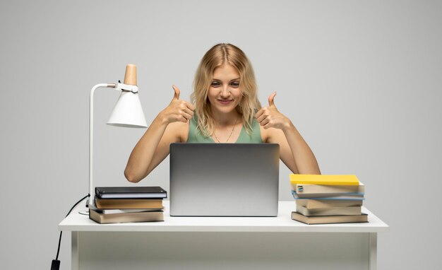 Photo portrait d'une jeune femme utilisant une tablette numérique debout sur un fond blanc