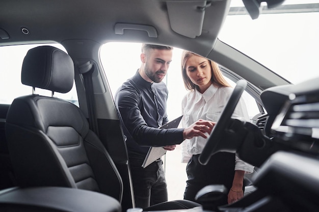 Portrait d'une jeune femme utilisant un téléphone portable alors qu'elle est assise dans une voiture