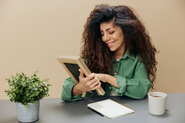 Photo portrait d'une jeune femme utilisant un téléphone portable assise sur une table