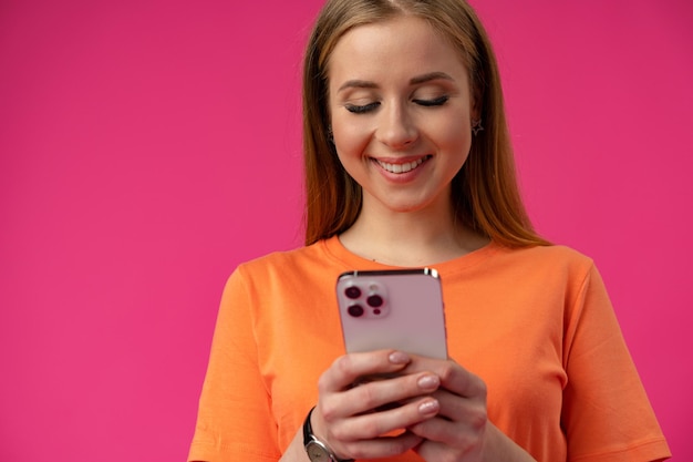 Portrait d'une jeune femme utilisant un téléphone portable sur un fond de couleur