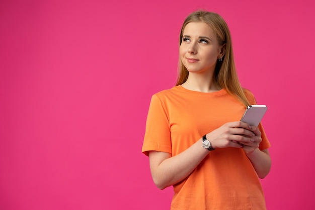 Portrait d'une jeune femme utilisant un téléphone portable sur un fond de couleur