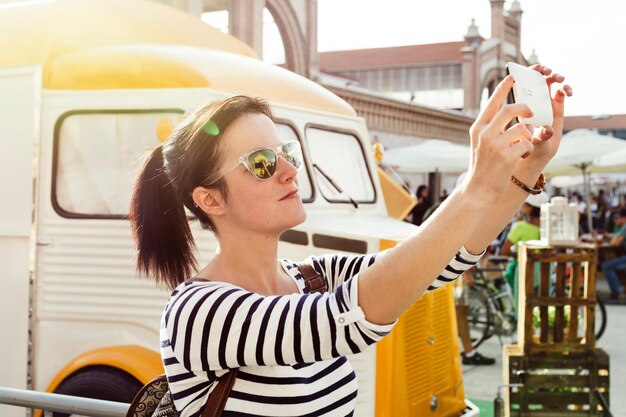 Photo portrait d'une jeune femme utilisant un téléphone portable