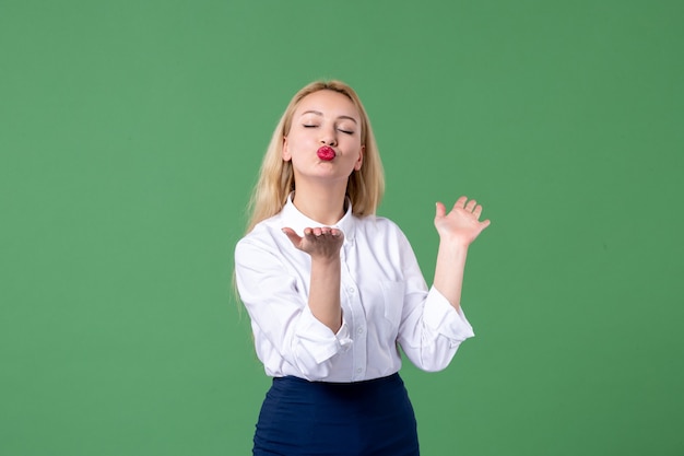 Portrait de jeune femme en vêtements conservateurs envoyant des baisers mur vert étudiant leçon étude femme de l'école