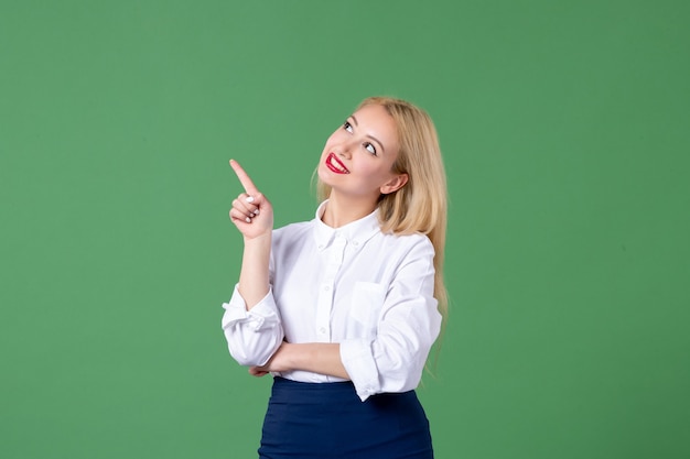 Portrait de jeune femme en vêtements conservateurs mur vert école d'étude de la leçon des enseignants