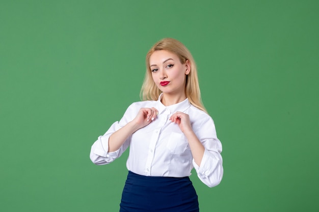 Portrait de jeune femme en vêtements conservateurs mur vert élèves professeur d'école leçon