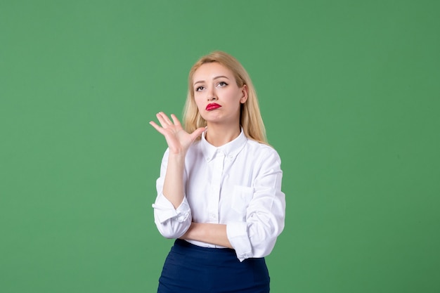 Portrait de jeune femme en vêtements conservateurs mur vert leçon élève enseignant école
