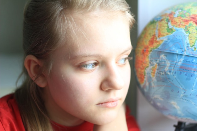 Portrait de jeune fille adolescente à la maison avec globe, gros plan