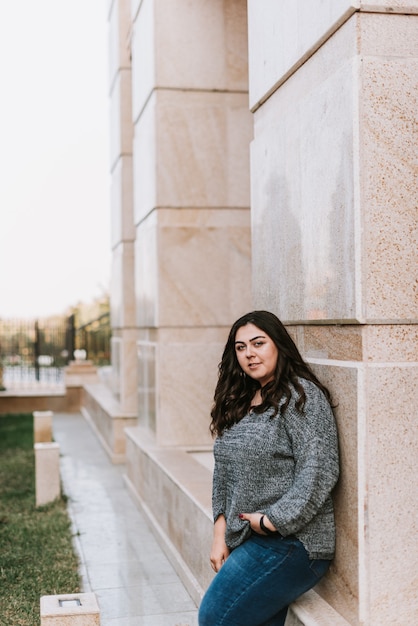 Portrait d'une jeune fille adulte sur le fond d'un bâtiment moderne