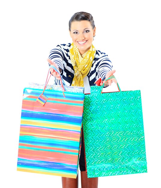 Portrait d'une jeune fille adulte heureuse, avec des sacs à code couleur.