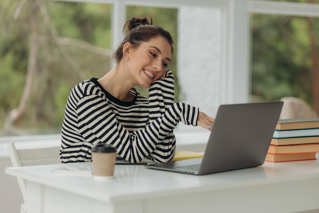 Portrait jeune fille à l'aide d'un ordinateur portable au bureau Étudiante travaillant à la maison Travail ou étude à domicile concept de style de vie d'entreprise indépendant