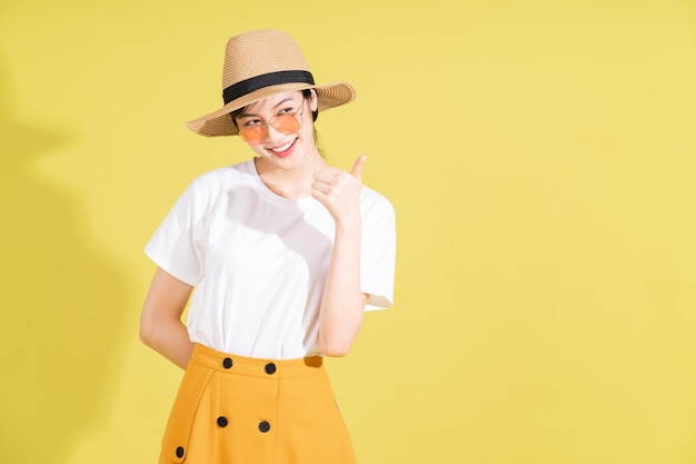 Portrait de jeune fille asiatique sur fond jaune